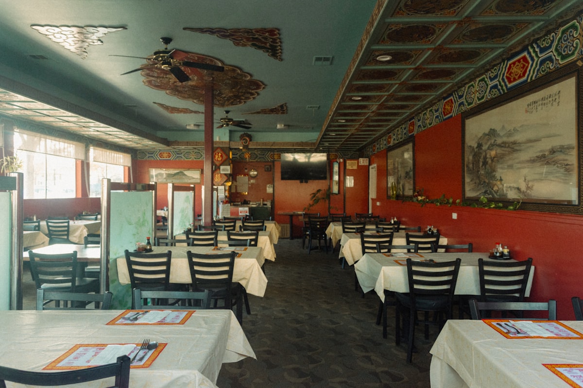 Manji restoran sa belim stolovima za porodičnu proslavu rođenja deteta